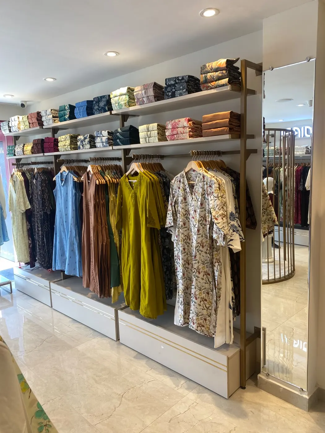 Wall shelving and hanging rails along a showroom wall