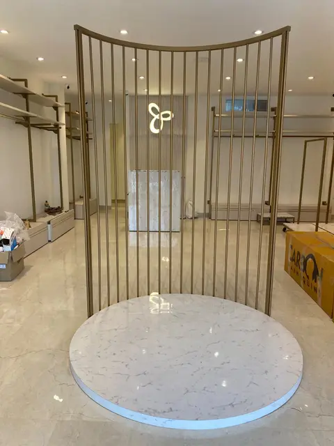 The curved brass-finish screen and marble plinth before styling